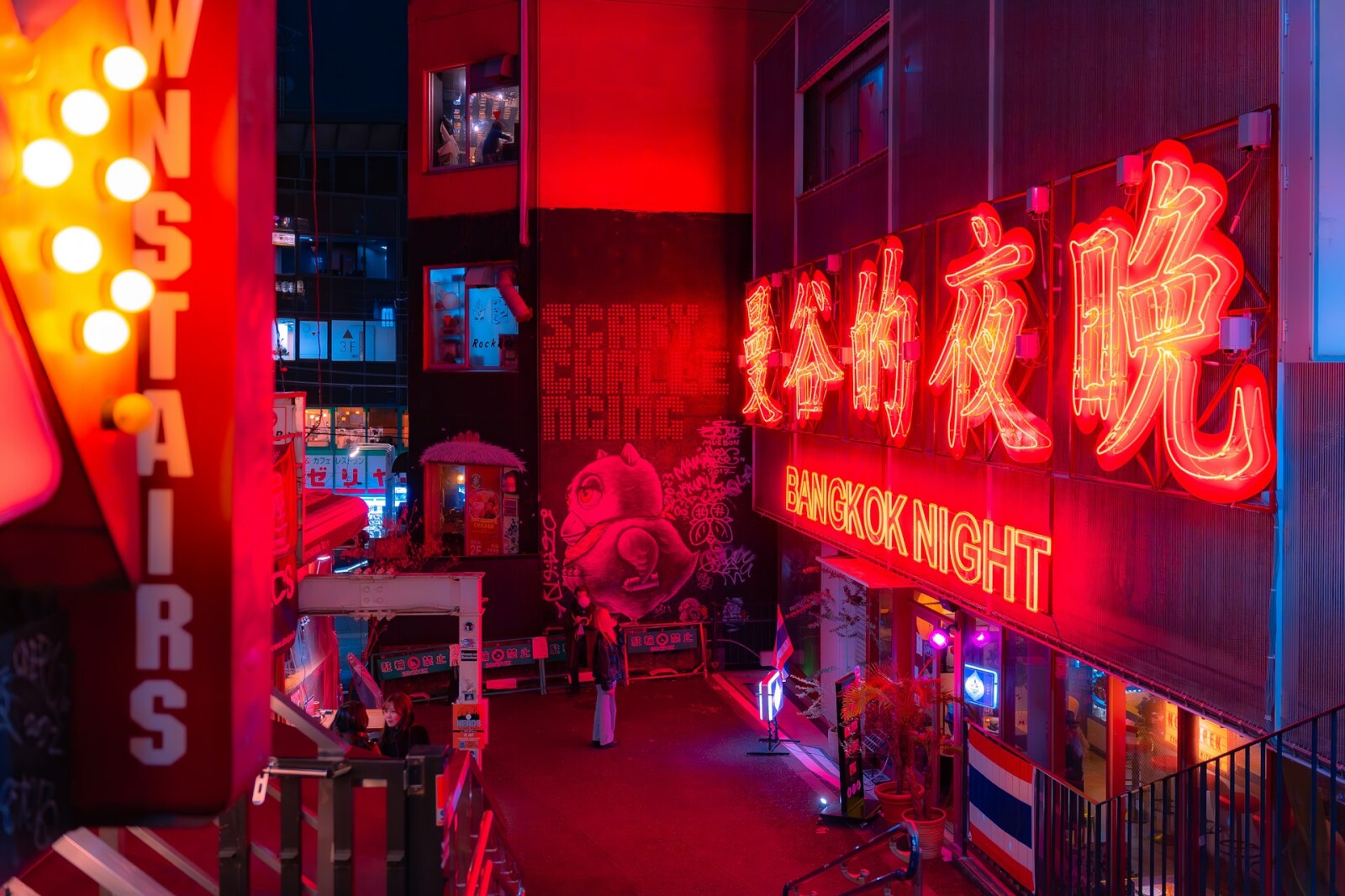 Vibrant urban alley with red neon signs, colorful graffiti, and people enjoying the lively nighttime atmosphere.